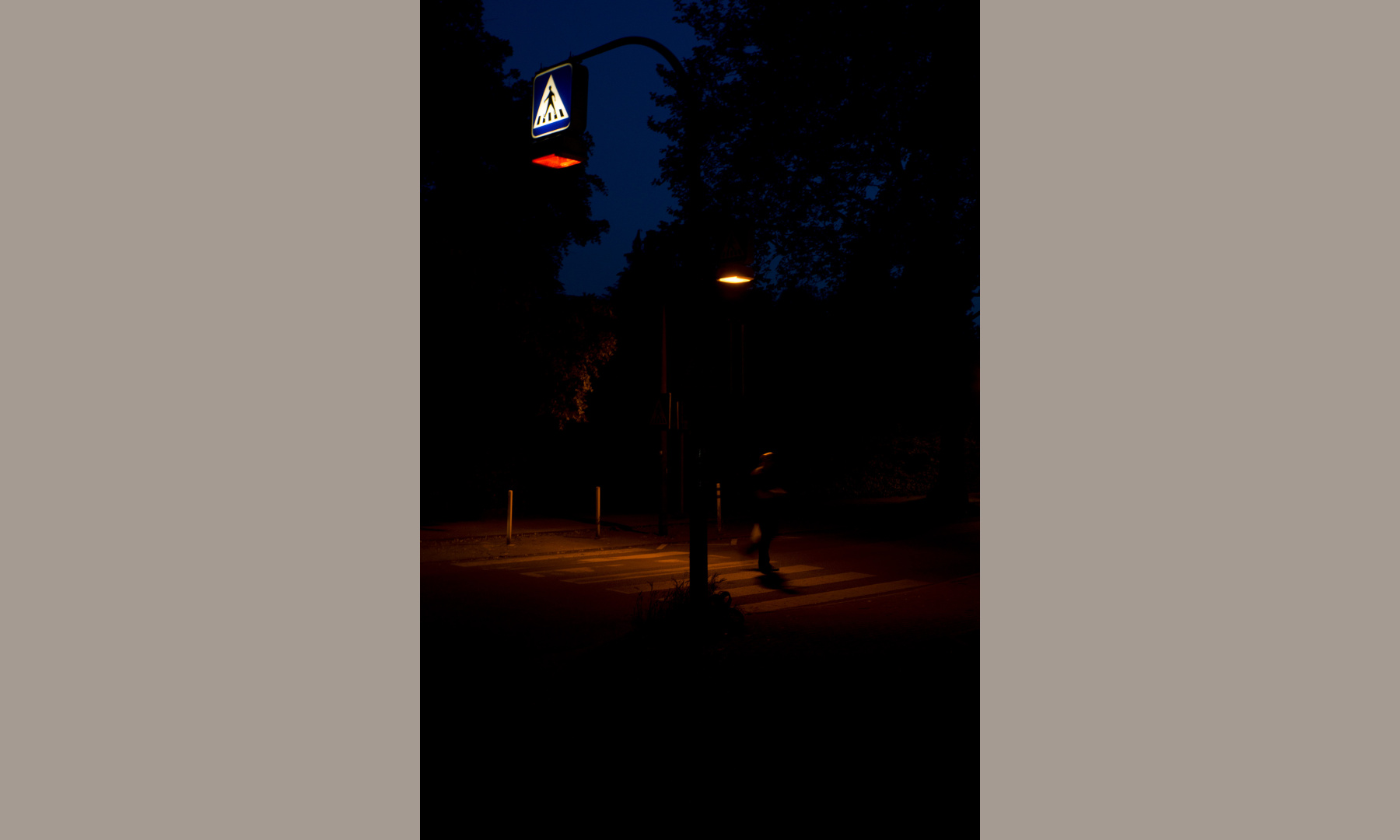 A crosswalk in shades of red at night