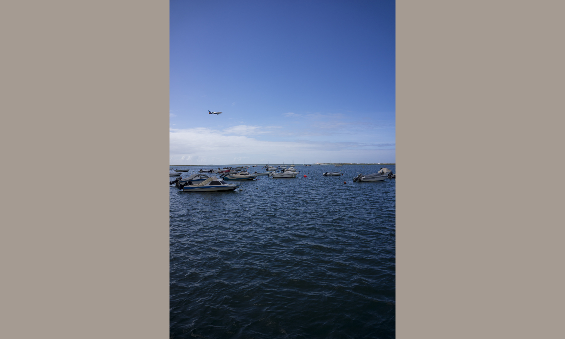 the blue sea and a plane during landing at Faro Airport, Portugal