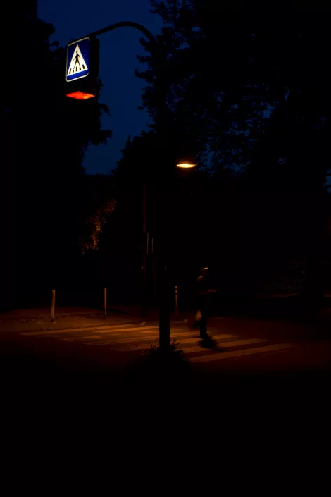 A crosswalk in shades of red at night