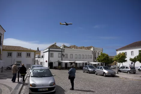A plane flights over the old city centre of Faro, Portugal